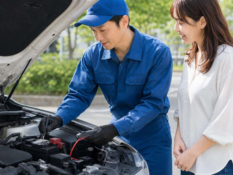 車のバッテリー上がりをブースター作業で復旧している様子